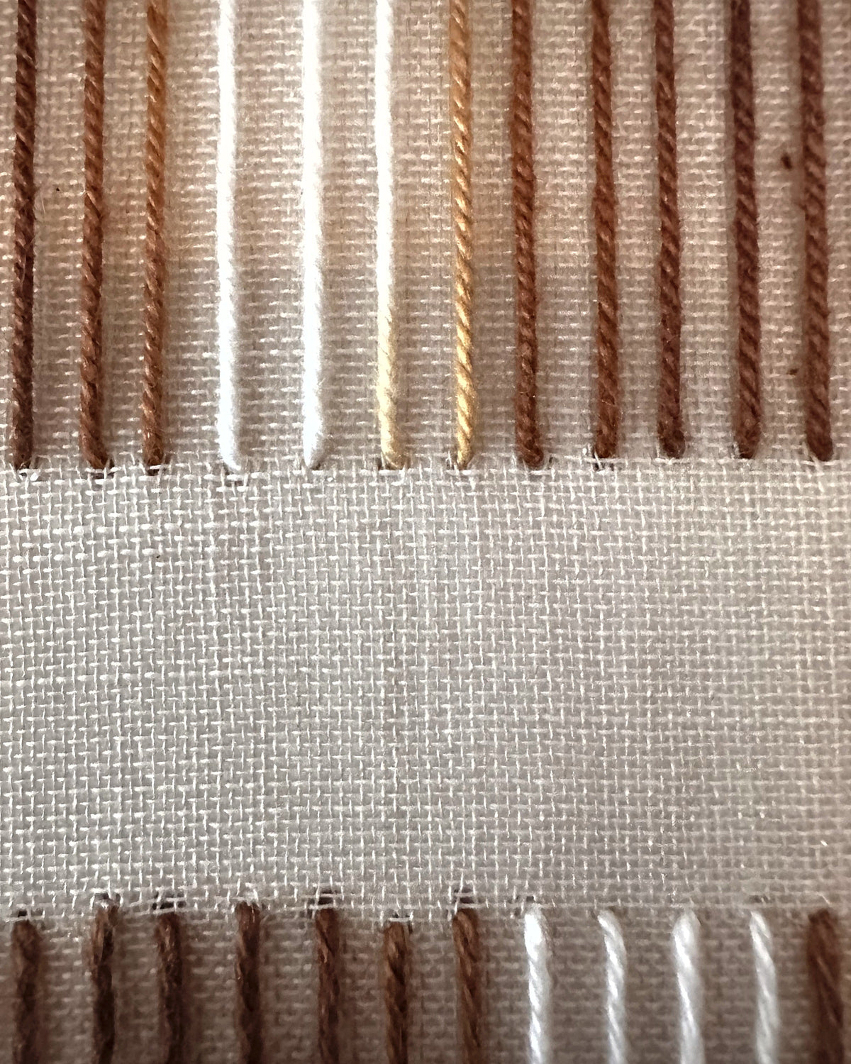Close-up of Andante by Nyra Atelier: twisted strands of brown and caramel wool hand-stitched over a cotton-and-wool weave