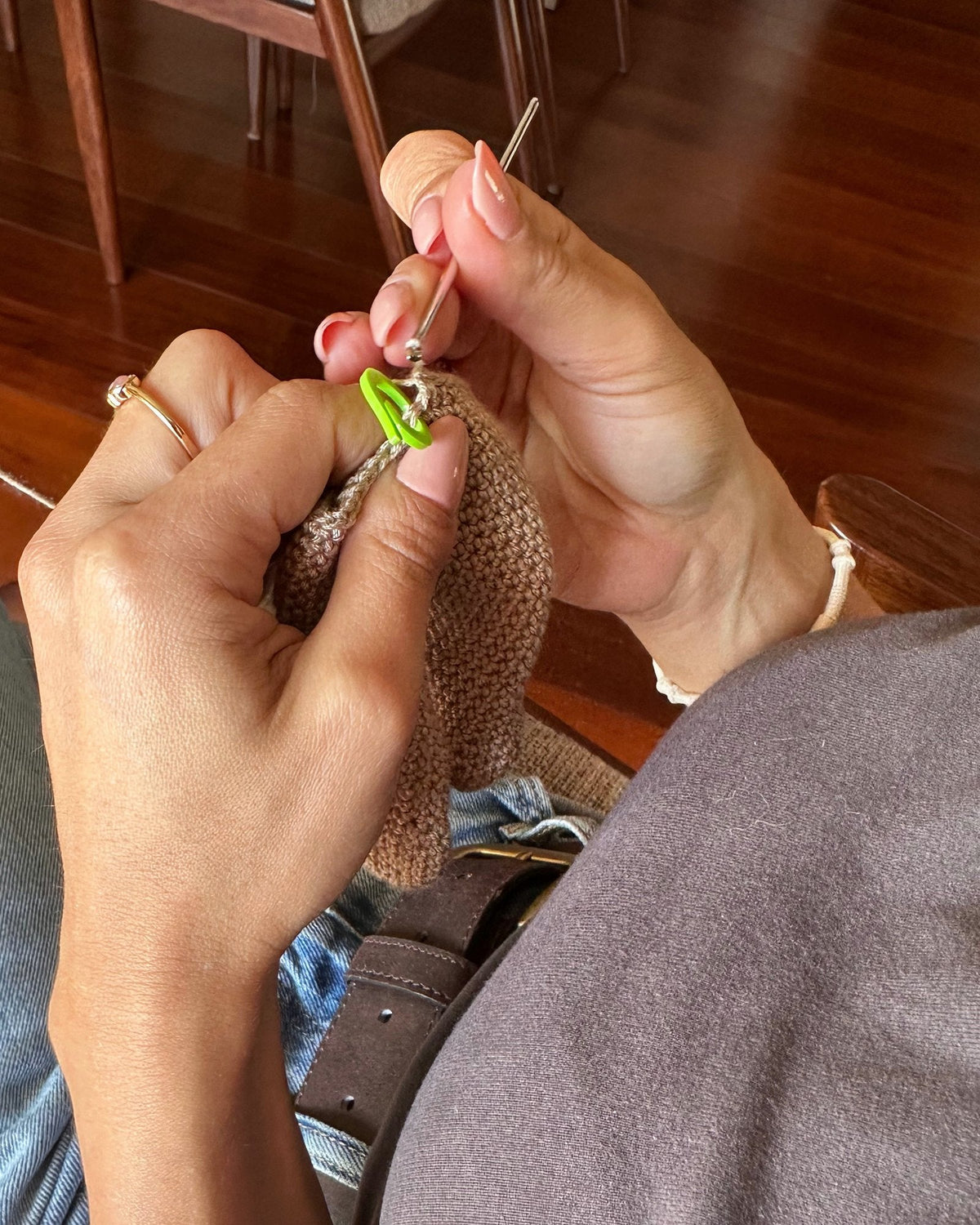 Las manos de Sónia Bizarro tejiendo una pieza de ganchillo con hilo de algodón natural y una aguja de ganchillo, en Nyra Atelier, en Oporto