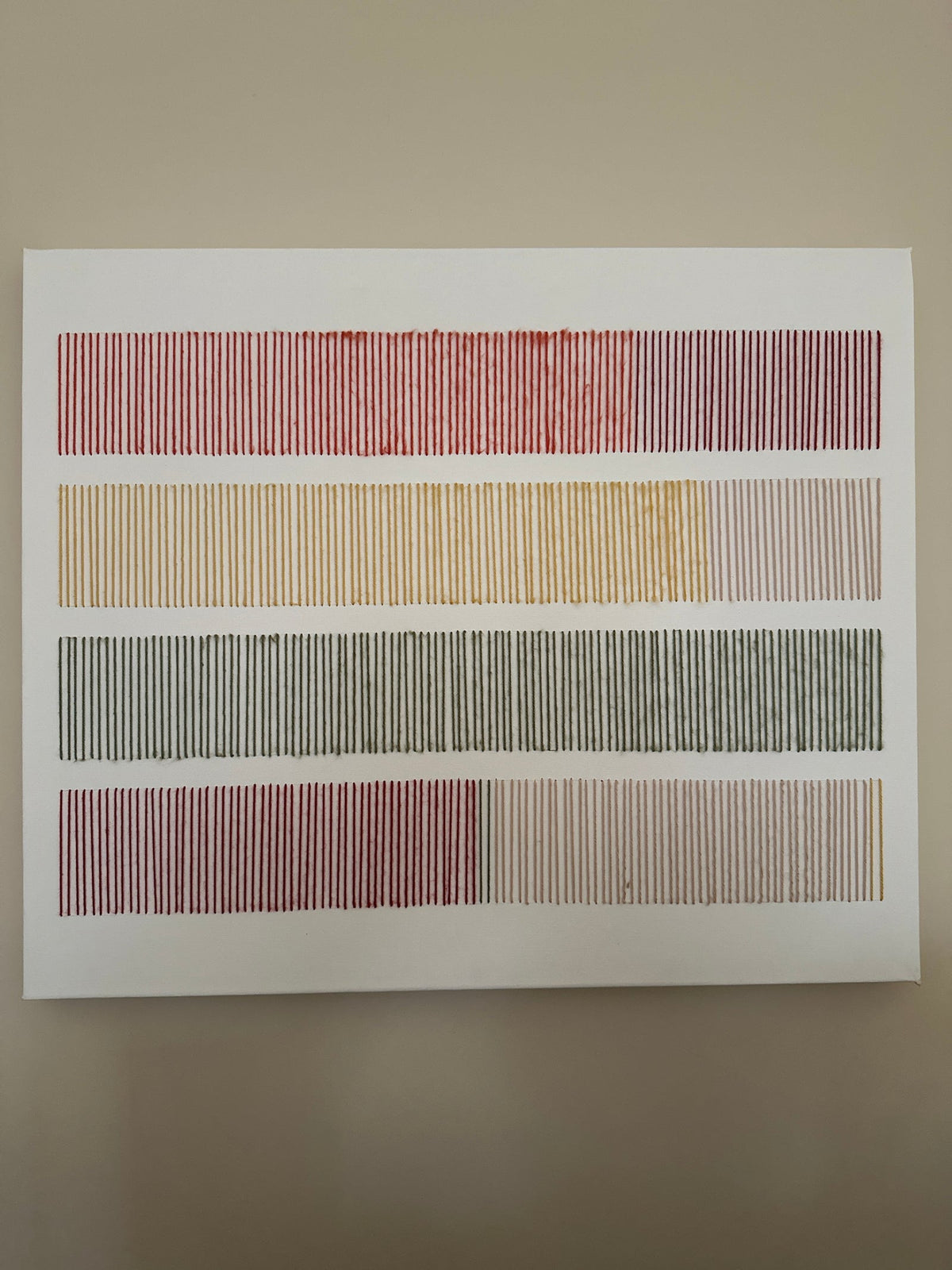 Cadence, lienzo de arte textil bordado a mano, con hileras de puntadas verticales de lana en rojo, mostaza, verde oliva y rosa palo