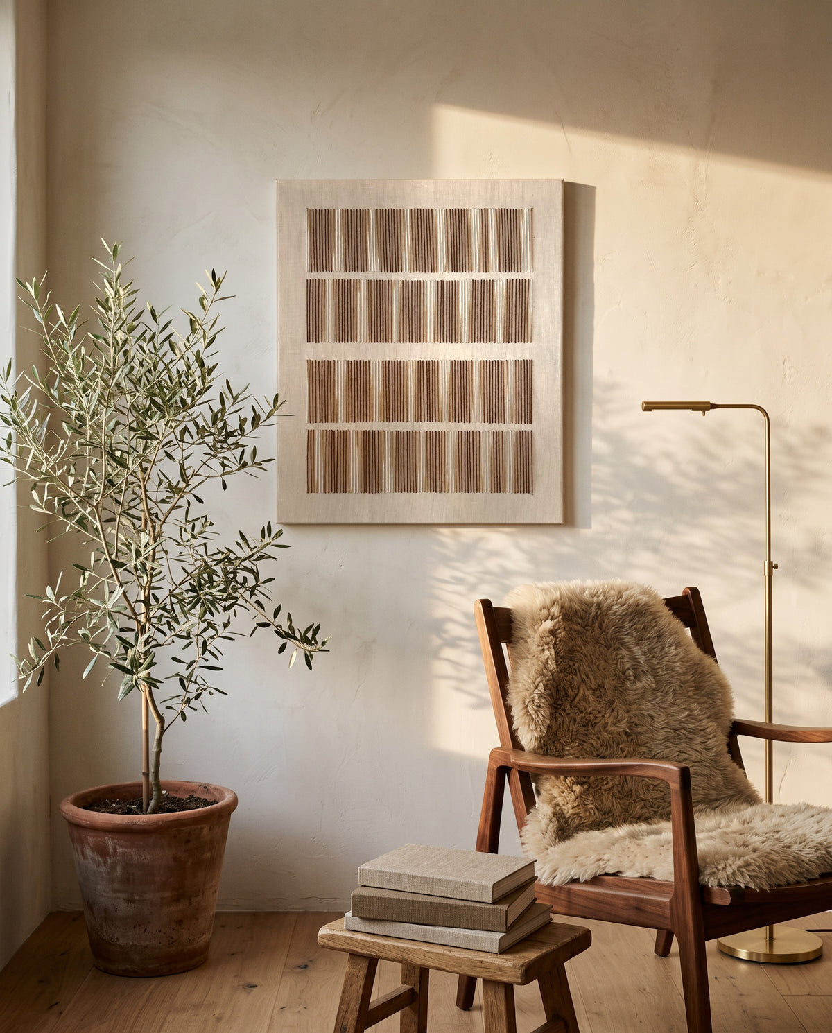 Andante, handmade wool wall art by Nyra Atelier, hung vertically in a sunlit reading corner with an olive tree, a wooden chair with a sheepskin and a stack of books. AI-assisted lifestyle image: the setting is illustrative and the canvas is our real product photo; please refer to our real product photographs for the actual item’s details.