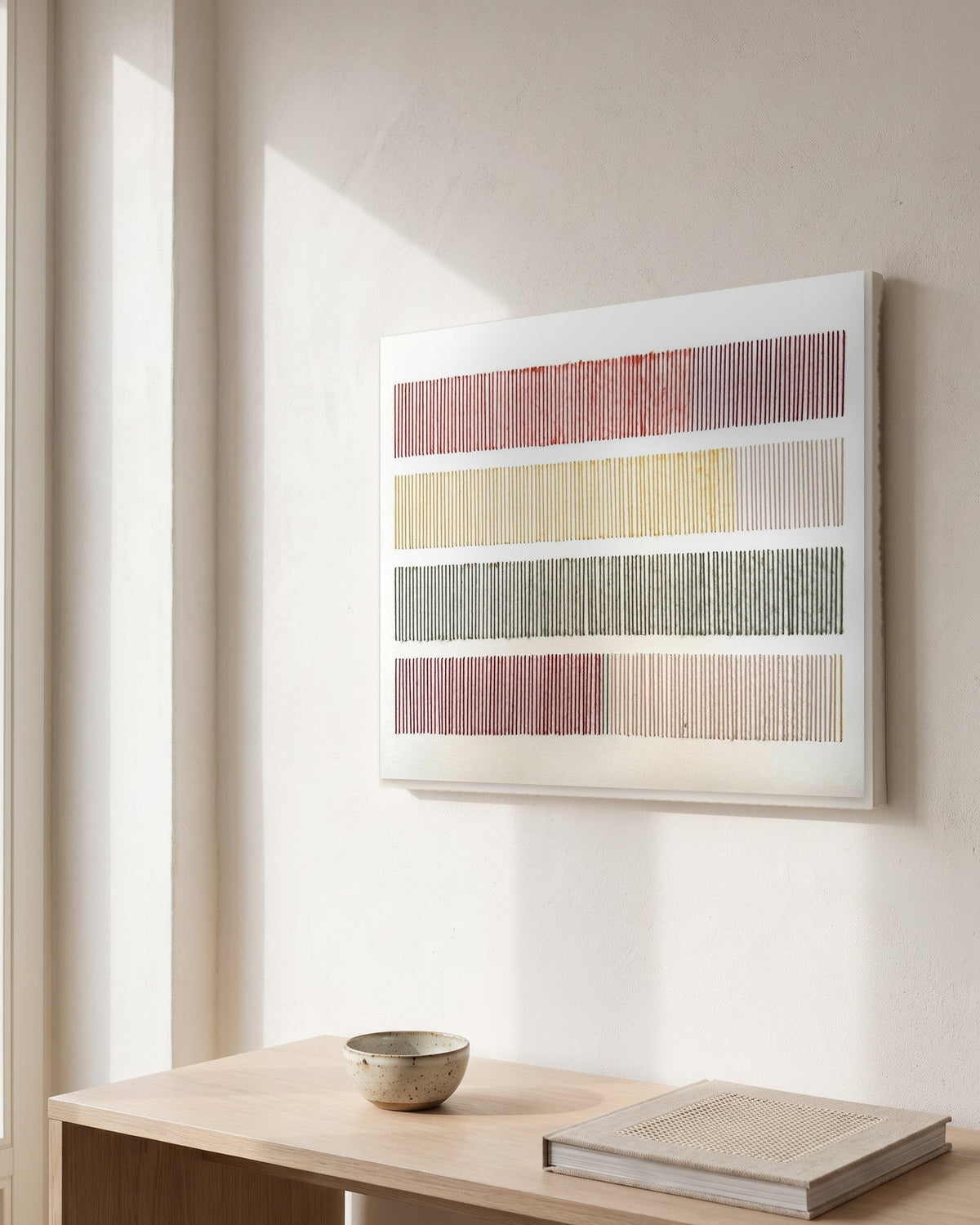 Cadence, hand-embroidered textile wall art by Nyra Atelier, hanging on a white plaster wall above a pale oak console with a stoneware bowl and a linen-bound book, in morning window light. AI-assisted lifestyle image: the setting is illustrative and the canvas is our real product photo; please refer to our real product photographs for the actual item’s details.