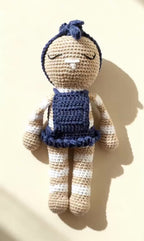 Video: Mia, handmade crochet bunny in her navy blue dress, standing against a cream background, with a slow zoom to her face