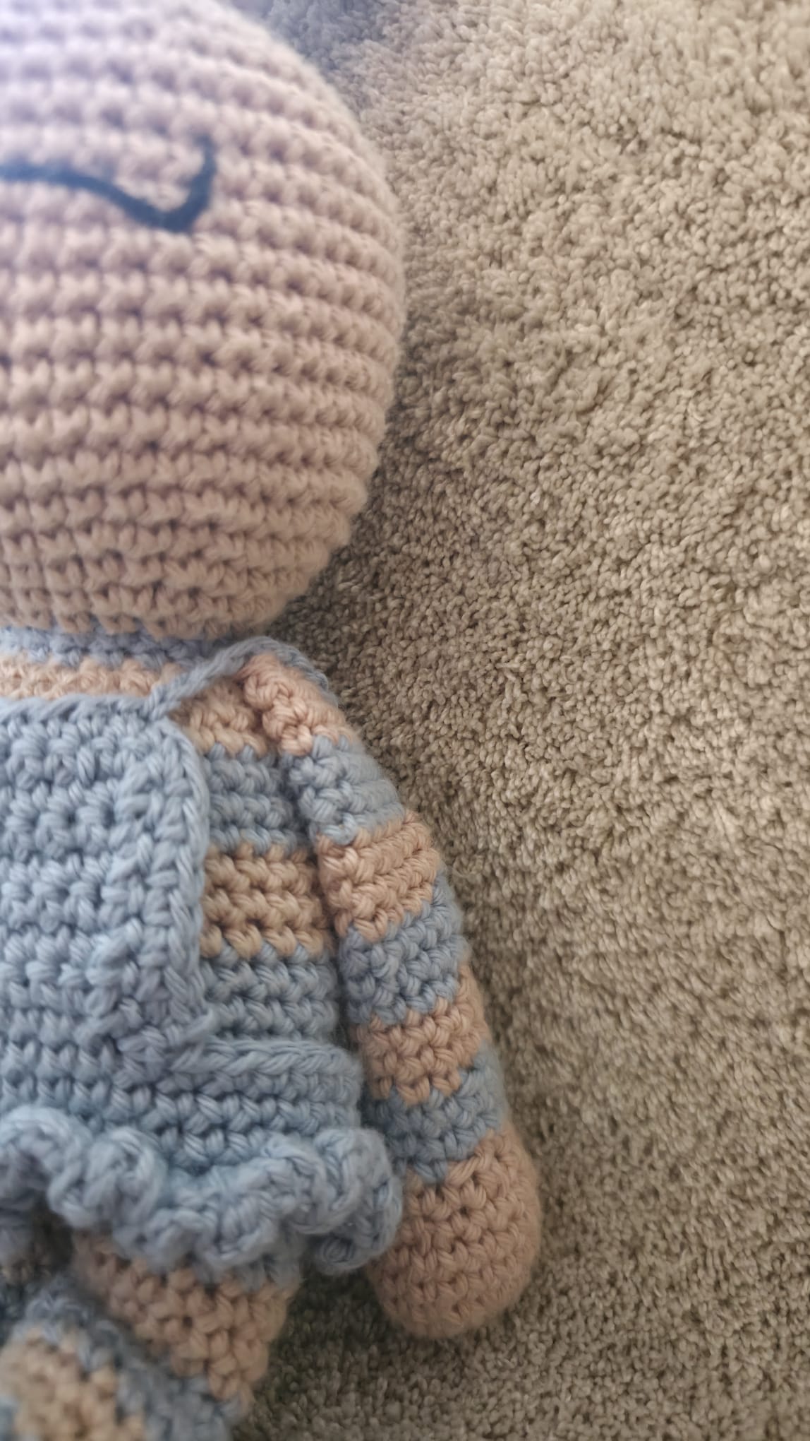 Close-up of Celeste's removable sky blue crochet dress with its ruffled hem, over her blue-and-beige striped body