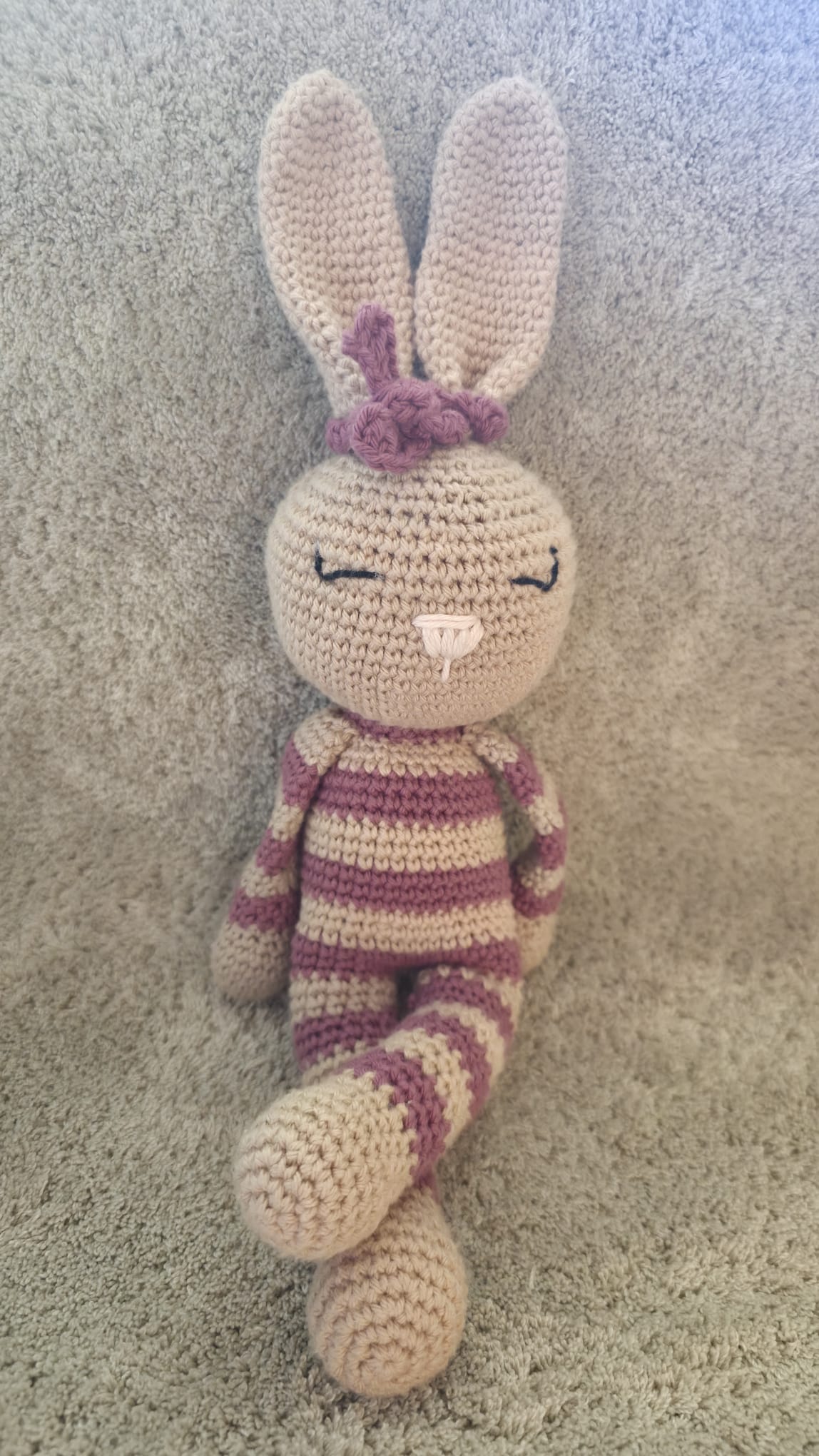 Rosa, handmade crochet bunny with pink and beige stripes, tan ears and a pink bow, standing