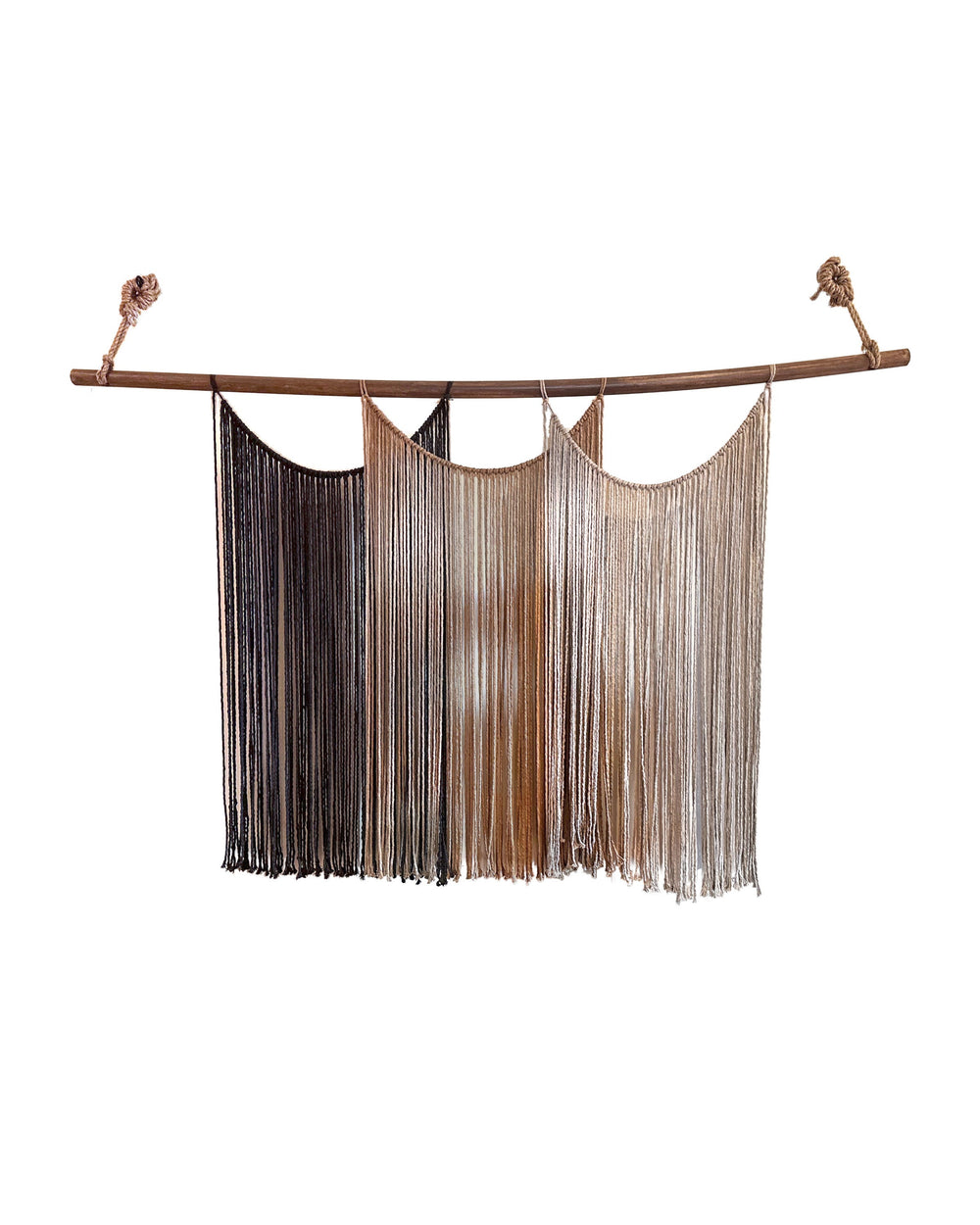 Suspenso Terra, large handmade macramé wall hanging by Nyra Atelier: three draped panels of deep brown, caramel and taupe cord on a natural wooden branch hung with knotted rope. Real photograph on a plain white wall.