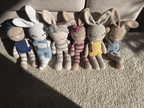 The Nyra Bunny Family: Mia, Theo, Luna, Rosa, Sol and Celeste, six handmade crochet bunnies by Nyra Atelier, sitting together in the afternoon sun.